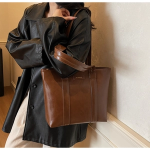 Détails du sac cabas en cuir marron foncé avec logo de marque et finition polie