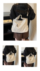 Detail view of large cream hobo bag with front zipper pocket and wide shoulder strap