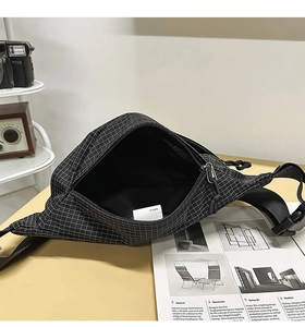 Detail view showing the spacious interior and white grid texture of the black sports waist bag
