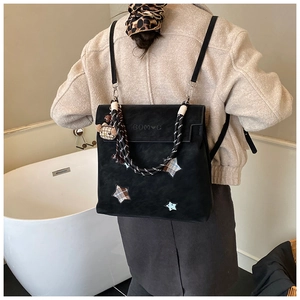 Détail d'un sac à dos noir mat étoilé avec poignée tissée et logo embossé