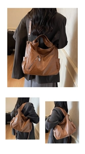 Macro detail of retro brown leather tote showing textured finish and decorative side zipper