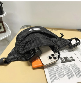 Detail view of checkered crossbody bag showing spacious interior for phone and camera