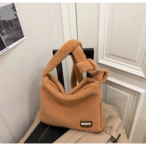 Detail of camel faux shearling tote bag with stylish knotted strap and logo patch