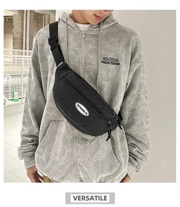 Detailed view of black checkered crossbody chest bag with adjustable strap and brand logo