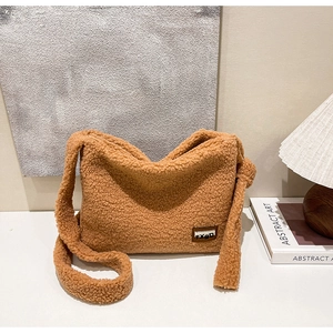 Detail shot of brown plush teddy fabric texture and TXBD label on a crossbody bag