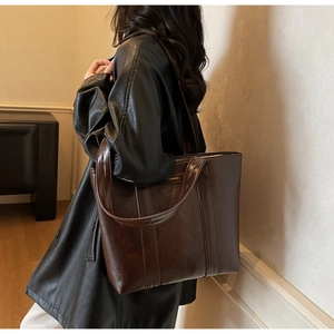 Détail du sac cabas vintage marron avec finition brillante et longue bandoulière