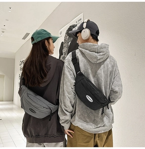 Detail of grid patterned crossbody chest bag shown on models in a modern minimalist setting