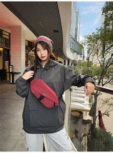 Outdoor shot of red and black checkered crossbody chest bag with adjustable buckle strap