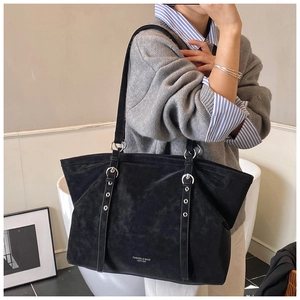 Detailed side view of black vintage leather tote bag with silver eyelet shoulder straps
