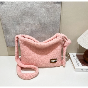 Detail of pink faux fur crossbody bag with soft texture and leather brand label