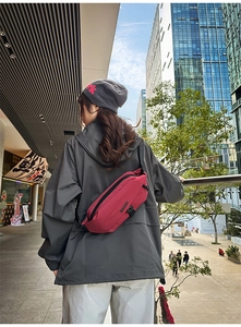 Urban lifestyle shot of a red plaid crossbody bag with TENGRUN logo on model back