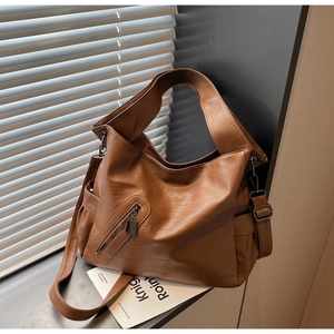 Detail view of large brown faux leather tote with textured finish and stylish zipper accent