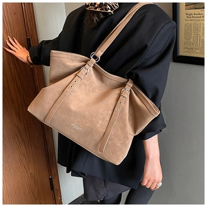 Detail of vintage khaki tote bag with fashion lettering and metallic buckle accents
