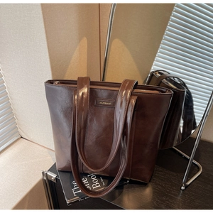 Vue détaillée du sac cabas en similicuir marron foncé avec texture lisse et logo