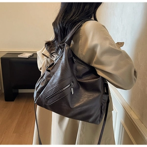 Detail of vintage dark brown tote bag with wrinkled texture and stylish metal zipper