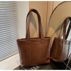 Gros plan sur un sac cabas vintage marron avec fermeture éclair et étiquette de marque