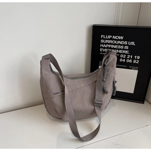 Detail of grey-purple hobo bag showing nylon texture and THREE TREE branding on side