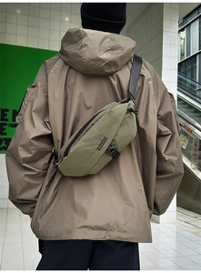 Detail showing military green waterproof crossbody chest bag with adjustable black strap