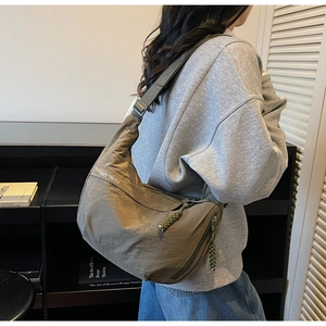 Detail of olive green crescent crossbody bag with white logo and adjustable shoulder strap