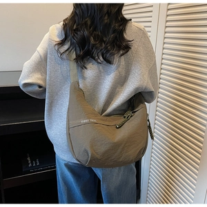 Olive green crescent nylon crossbody bag showing the large capacity and woven zipper detail