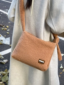 Fuzzy camel faux fur crossbody bag for women with wide strap in autumn street setting