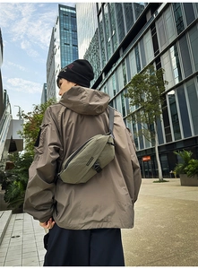 Outdoor shot of olive green cross-body chest bag with durable ripstop fabric and adjustable strap