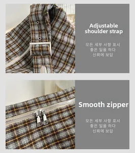 Detail of adjustable shoulder strap with silver buckle and smooth metal zipper on plaid bag