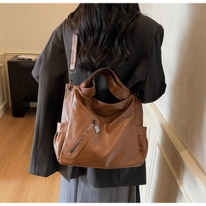 Detail view of large brown vintage tote bag with wide strap for versatile daily commute