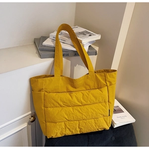 Detail of yellow quilted tote bag showing large capacity design and soft fabric texture