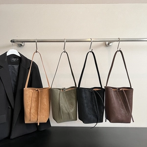 Detailed view of four retro bucket bags in khaki, green, black and brown premium textures