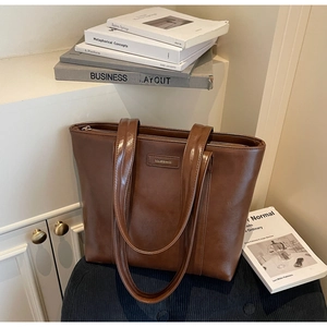 Détail du grand sac cabas vintage marron avec logo et texture en cuir brillant