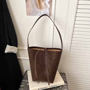 Detail view of a vintage dark brown matte leather bucket bag with drawstring closure