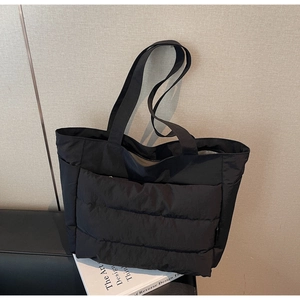 Close-up of quilted nylon tote bag with puffer padding details and soft texture