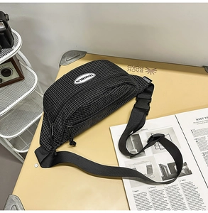 Detail of checkered crossbody bag with adjustable nylon strap and plastic buckle closure