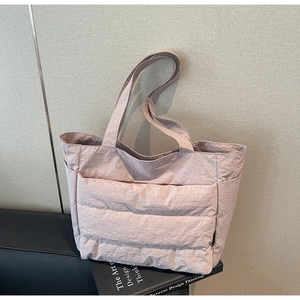 Detail of light pink quilted tote bag with pleated nylon texture and large capacity