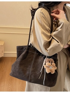 Large dark brown suede tote bag with white contrast stitching and plush dog charm