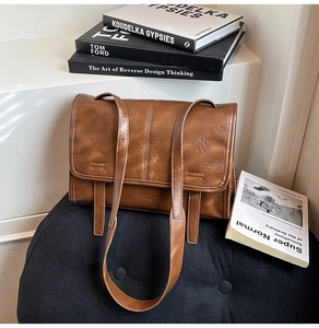 Detailed view of the vintage brown leather shoulder bag texture with twin strap decor