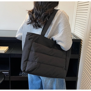 Detail showing side view of black quilted tote bag for women in office commute style