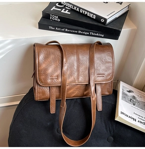 Detail view of brown vintage textured shoulder bag with adjustable straps and flap design