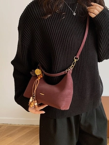 Deep red crescent crossbody bag with wood bead tassel and adjustable leather strap