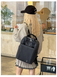 Detail showing high-density black quilted backpack with silver zippers and a bunny icon
