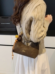 Brown suede half-moon shoulder bag with colorful ethnic pompom and wooden bead charms