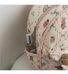 Détail de poche latérale sur sac à dos à fleurs avec ours et tissu plissé rose