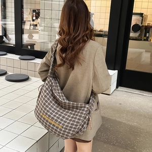 Close-up of large canvas shoulder bag featuring retro plaid pattern and embroidery