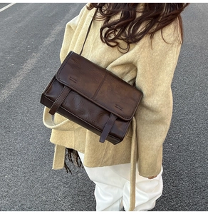 Detailed outdoor view of retro dark brown crossbody bag with oil wax leather texture