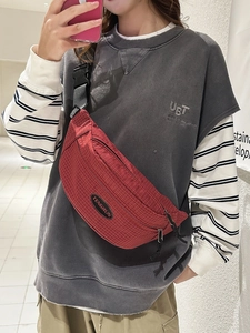 Red checkered sports crossbody bag with adjustable strap and logo displayed on model