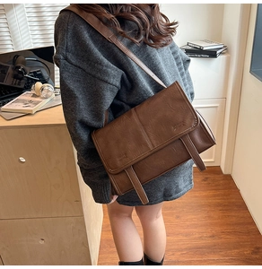 Lifestyle shot of a vintage brown leather crossbody bag with long straps on a female model