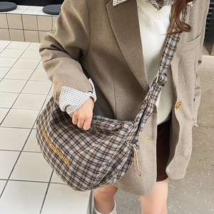 Detail of blue and brown plaid canvas hobo bag featuring yellow letter embroidery
