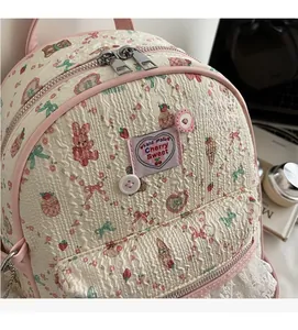 Détail du sac à dos rose matelassé avec motifs de jolis motifs de lapins et bordure en dentelle