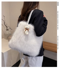 Detail of white fluffy faux fur tote bag with braided handle and cute teddy bear charm